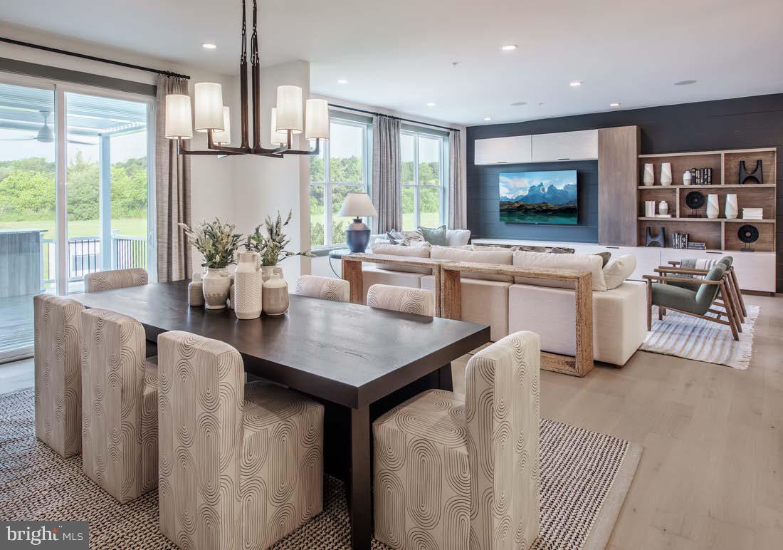 a open kitchen with stainless steel appliances granite countertop a stove a refrigerator a kitchen island a table and chairs