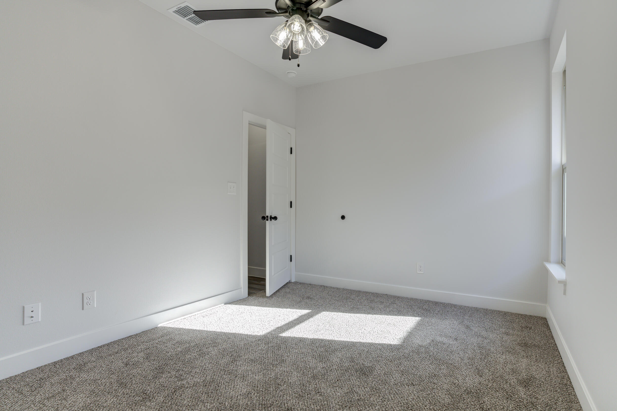 1005 Quincy Avenue Lubbock, TX 79416 - Photo 12 of 46 an empty room with a ceiling fan and carpet