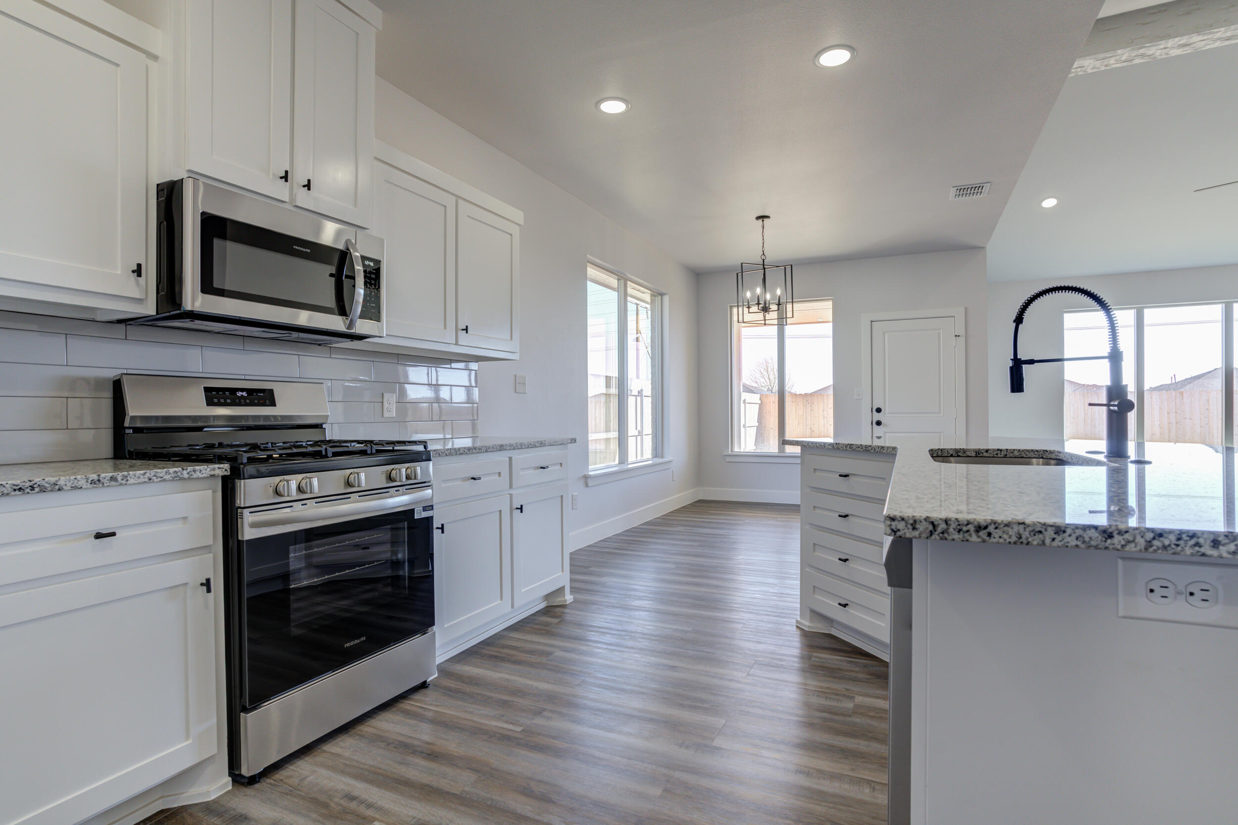 1005 Quincy Avenue Lubbock, TX 79416 - Photo 17 of 46 a kitchen with stainless steel appliances granite countertop a stove a sink and a microwave