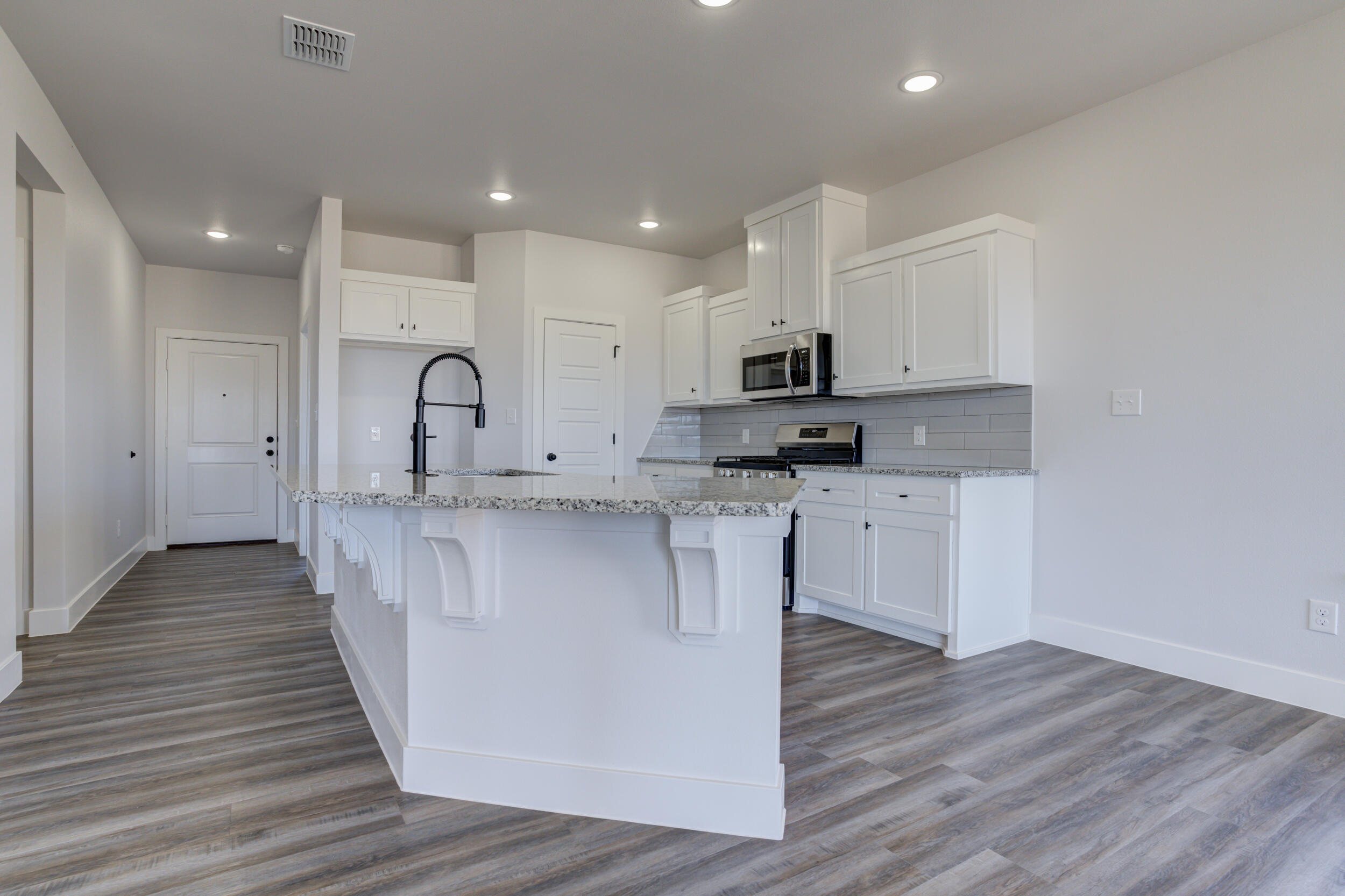 1005 Quincy Avenue Lubbock, TX 79416 - Photo 22 of 46 a kitchen with kitchen island granite countertop a sink cabinets and wooden floor
