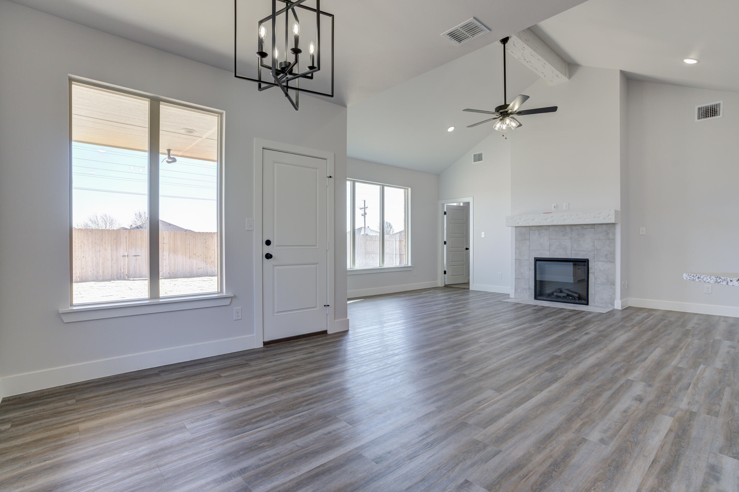 1005 Quincy Avenue Lubbock, TX 79416 - Photo 24 of 46 a view of an empty room with wooden floor fireplace and a window