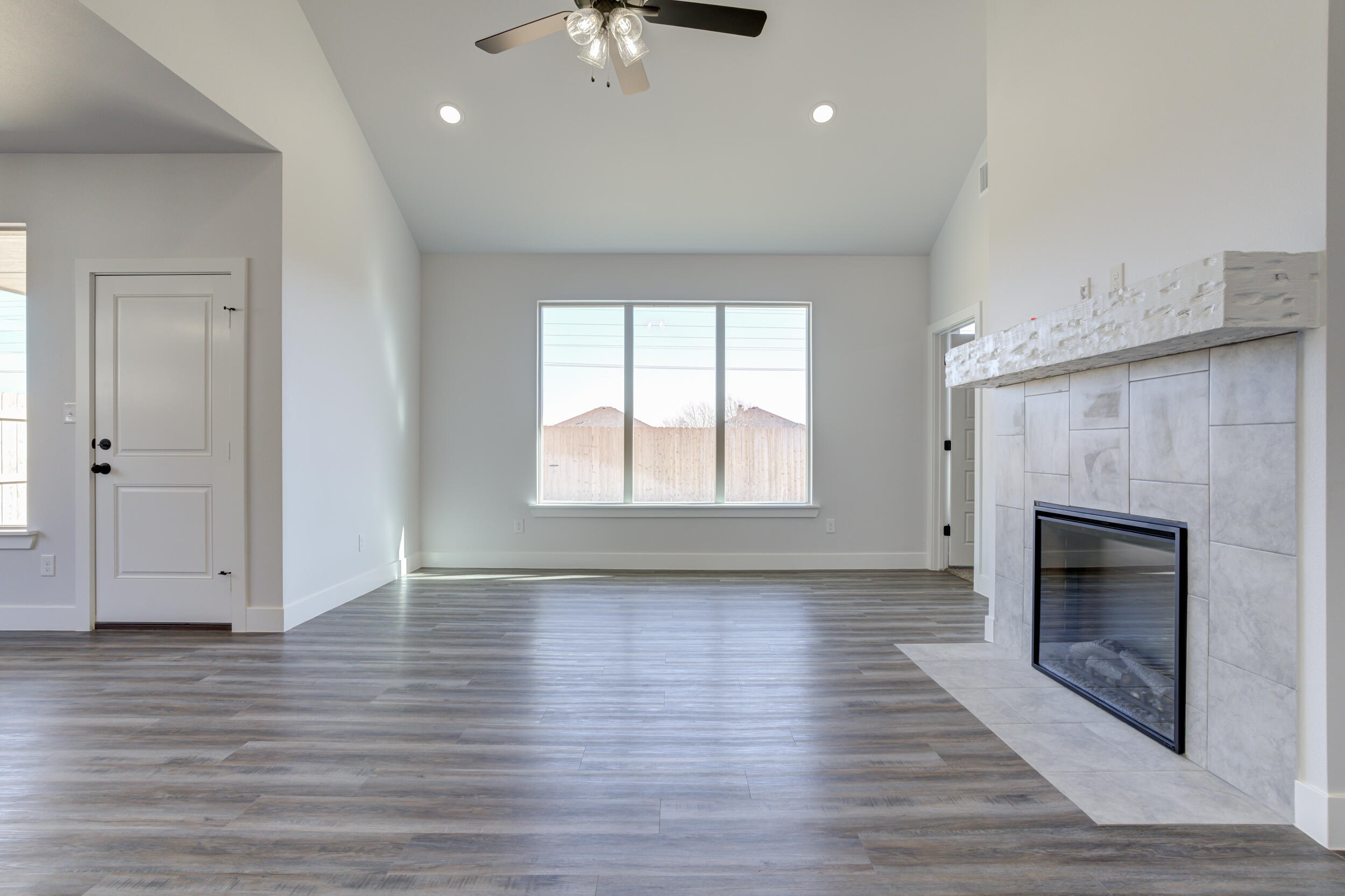 1005 Quincy Avenue Lubbock, TX 79416 - Photo 31 of 46 an empty room with wooden floor fireplace and windows