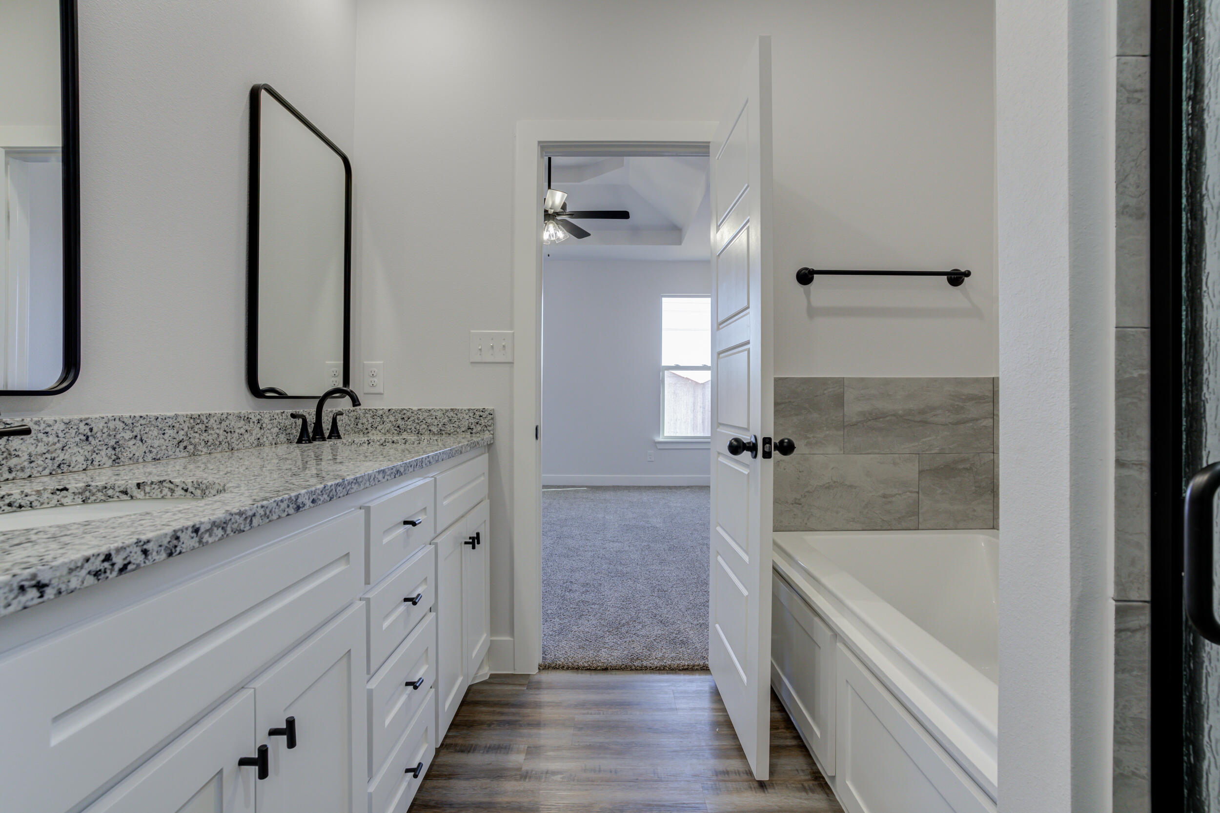 1005 Quincy Avenue Lubbock, TX 79416 - Photo 39 of 46 a bathroom with a granite countertop bathtub shower and a sink