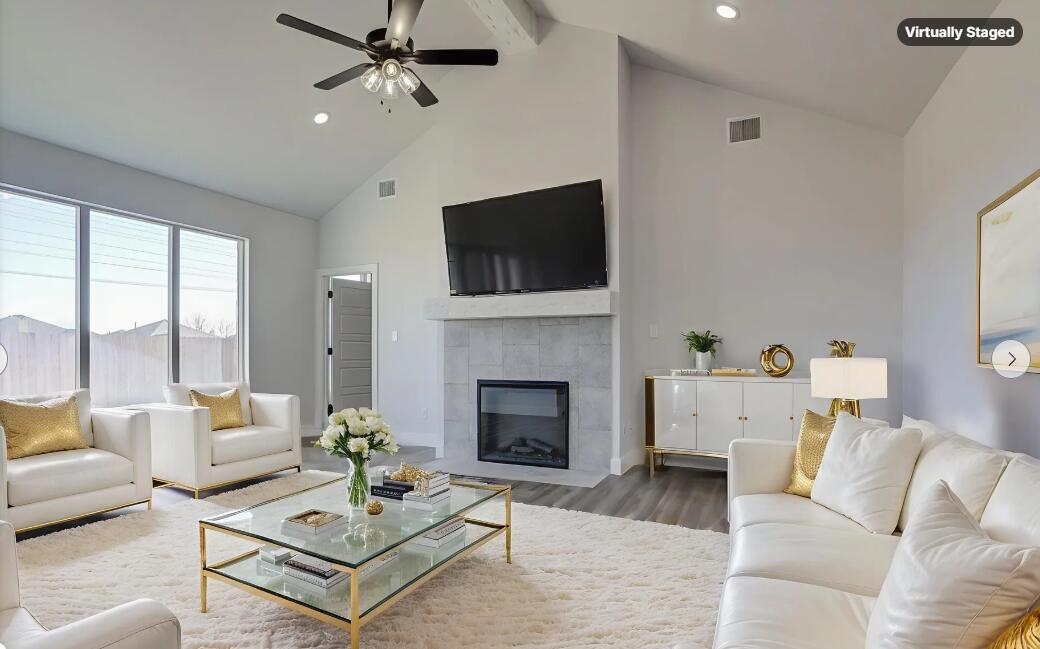 1005 Quincy Avenue Lubbock, TX 79416 - Photo 4 of 46 a living room with furniture a flat screen tv and a fireplace