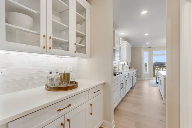 a large white kitchen with sink and stainless steel appliances