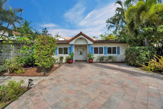 a front view of a house with a yard and potted plants