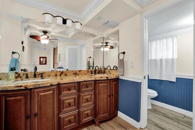 a spacious bathroom with a granite countertop sink and a mirror
