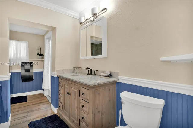 a spacious bathroom with a granite countertop sink a toilet and a mirror
