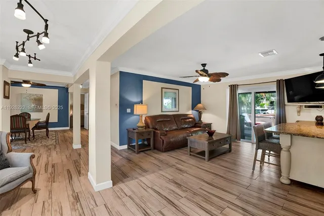 a living room with furniture a dining table and wooden floor