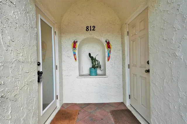 a view of a hallway with a white door and wooden floor