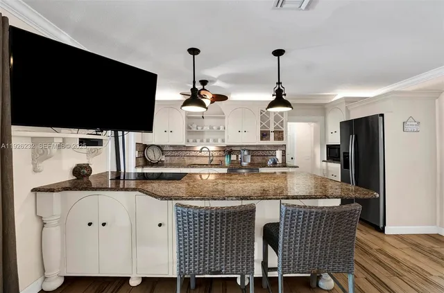 a kitchen with stainless steel appliances granite countertop a sink a stove and a refrigerator