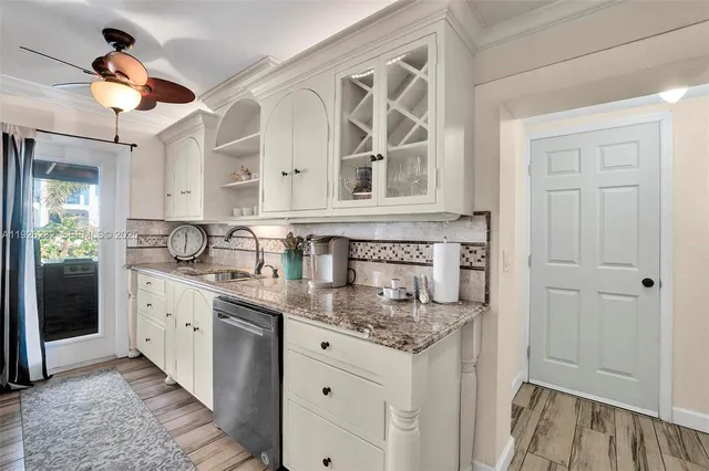 a kitchen with granite countertop a sink stainless steel appliances and cabinets