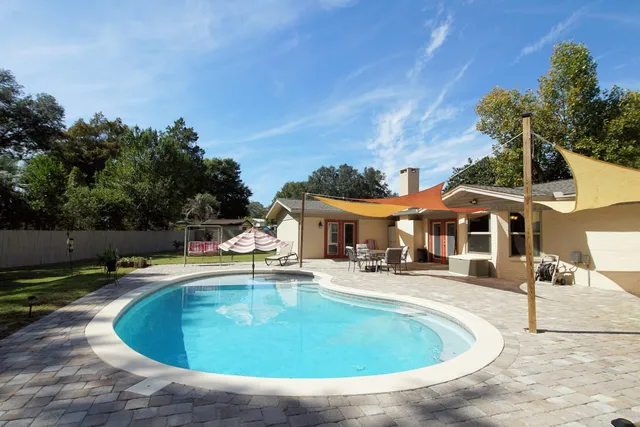 a view of a house with swimming pool and sitting area