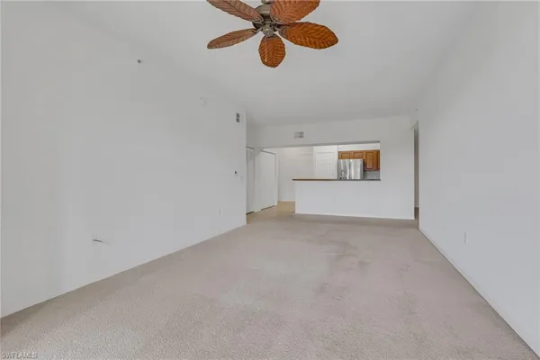 a view of a room with a ceiling fan and a window