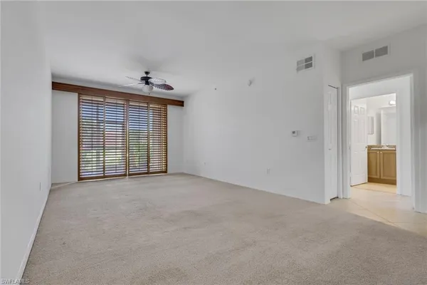 an empty room with window and ceiling fan