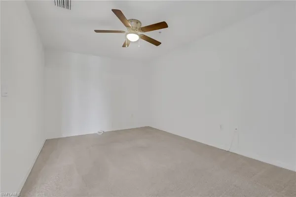 an empty room with closet and a chandelier fan