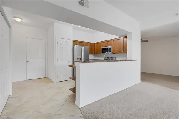 a kitchen with stainless steel appliances granite countertop a sink and a refrigerator