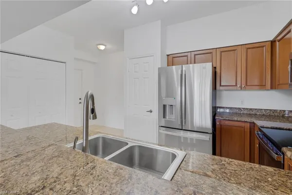 a kitchen with stainless steel appliances granite countertop a refrigerator and a sink