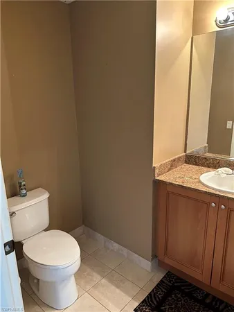 a bathroom with a granite countertop toilet and a sink