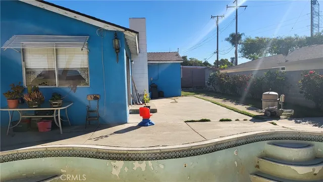 a swimming pool with barbeque oven in front of it
