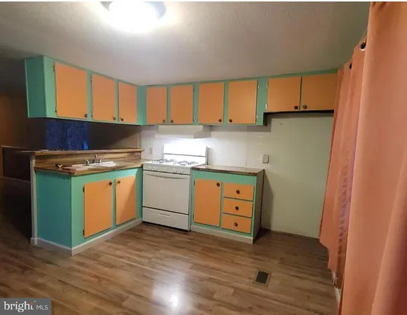 a kitchen with a stove a sink and a window