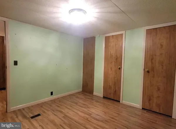 an empty room with closet and wooden floor
