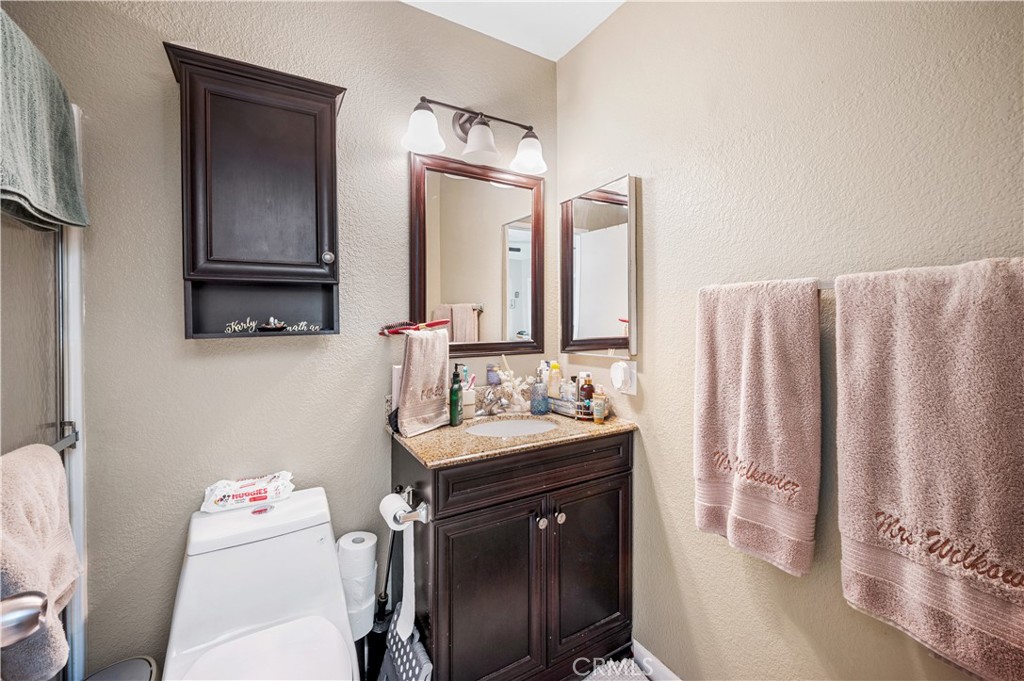 47800 Madison Street, Unit 174 Indio, CA 92201 - Photo 13 of 24 a bathroom with a sink vanity mirror and toilet