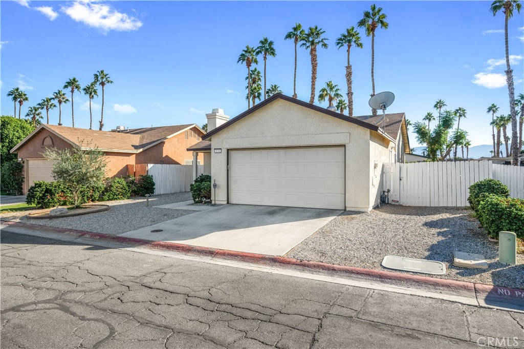 47800 Madison Street, Unit 174 Indio, CA 92201 - Photo 2 of 24 a front view of a house with a yard and garage