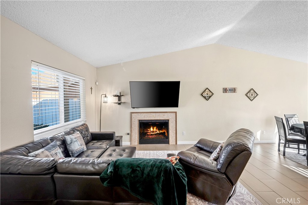 47800 Madison Street, Unit 174 Indio, CA 92201 - Photo 3 of 24 a living room with furniture flat screen tv and a fireplace