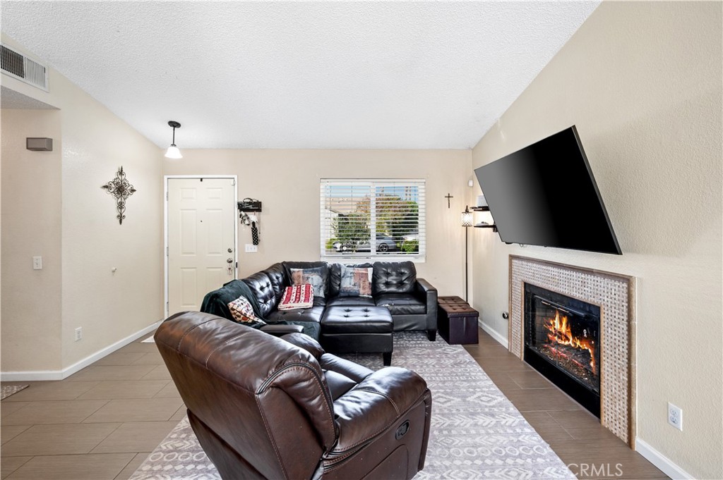 47800 Madison Street, Unit 174 Indio, CA 92201 - Photo 4 of 24 a living room with furniture a flat screen tv and a fireplace