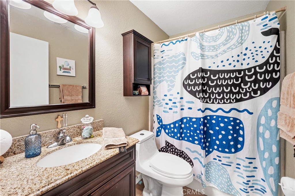 47800 Madison Street, Unit 174 Indio, CA 92201 - Photo 10 of 24 a bathroom with a toilet a sink and mirror