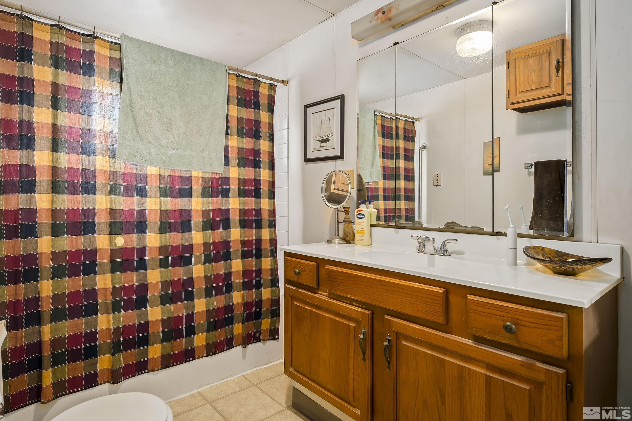 1078 Haskell Street Reno, NV 89509 - Photo 11 of 15 a bathroom with a sink a large mirror and a shower