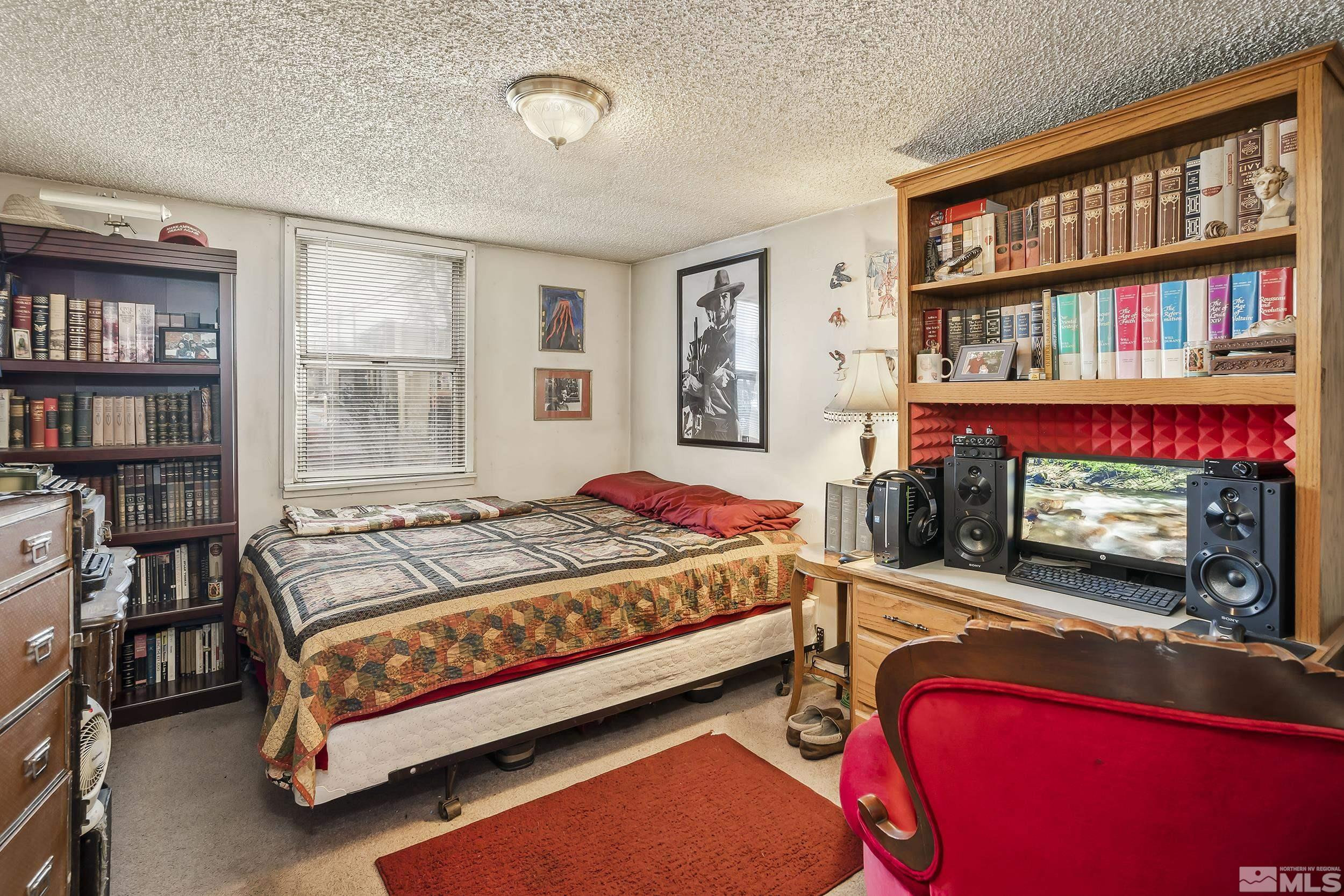 1078 Haskell Street Reno, NV 89509 - Photo 13 of 15 a bedroom with a bed bookshelf and a large window