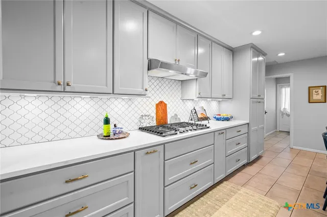 a kitchen with granite countertop white cabinets and white appliances