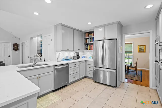 a kitchen with stainless steel appliances granite countertop a refrigerator and a sink
