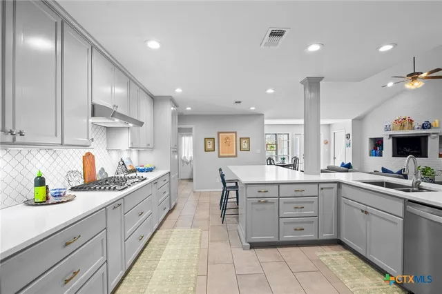a kitchen with a sink white cabinets and counter space