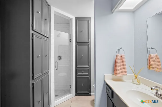 a bathroom with a granite countertop shower a sink and a mirror