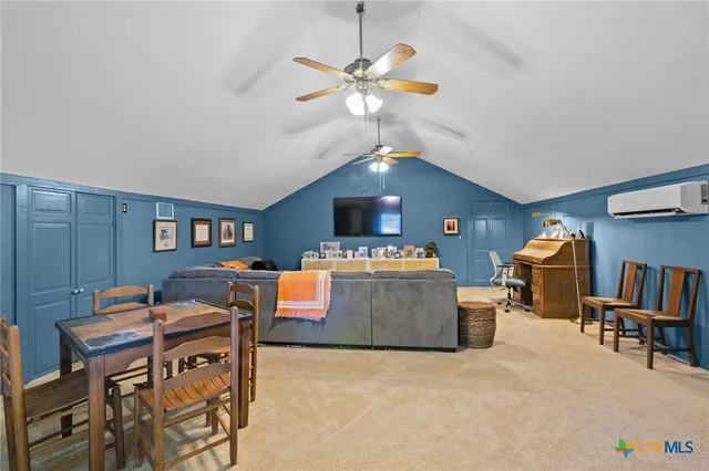 a living room with furniture and a ceiling fan