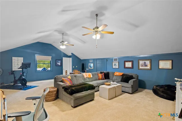 a living room with furniture a chandelier and a flat screen tv