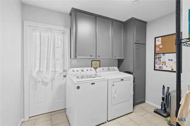 a utility room with cabinets washer and dryer