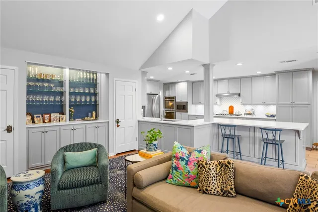 a living room with furniture and kitchen view