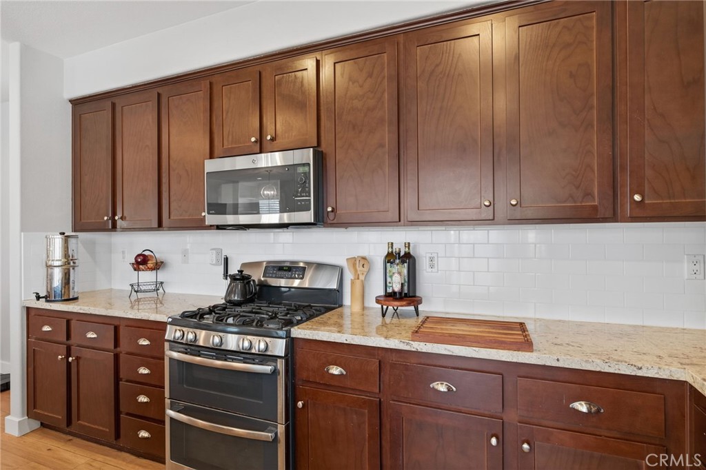 3459 North Oxnard Boulevard Oxnard, CA 93036 - Photo 13 of 54 a kitchen with granite countertop wooden cabinets and a stove top oven