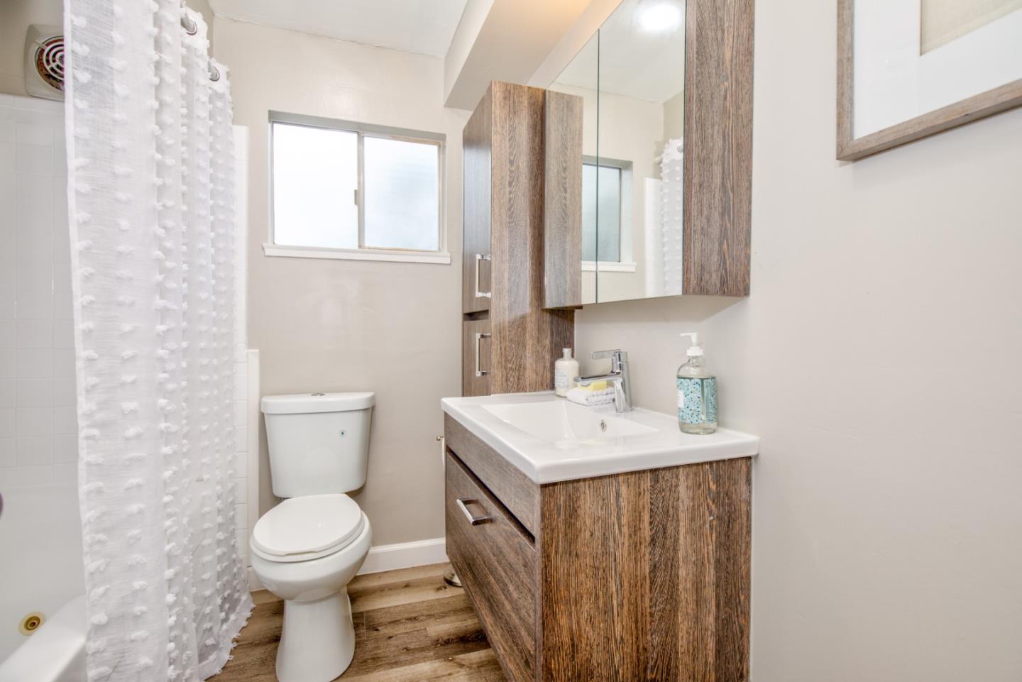865 Sunset Drive San Carlos, CA 94070 - Photo 11 of 26 a bathroom with a toilet a sink a mirror and a window