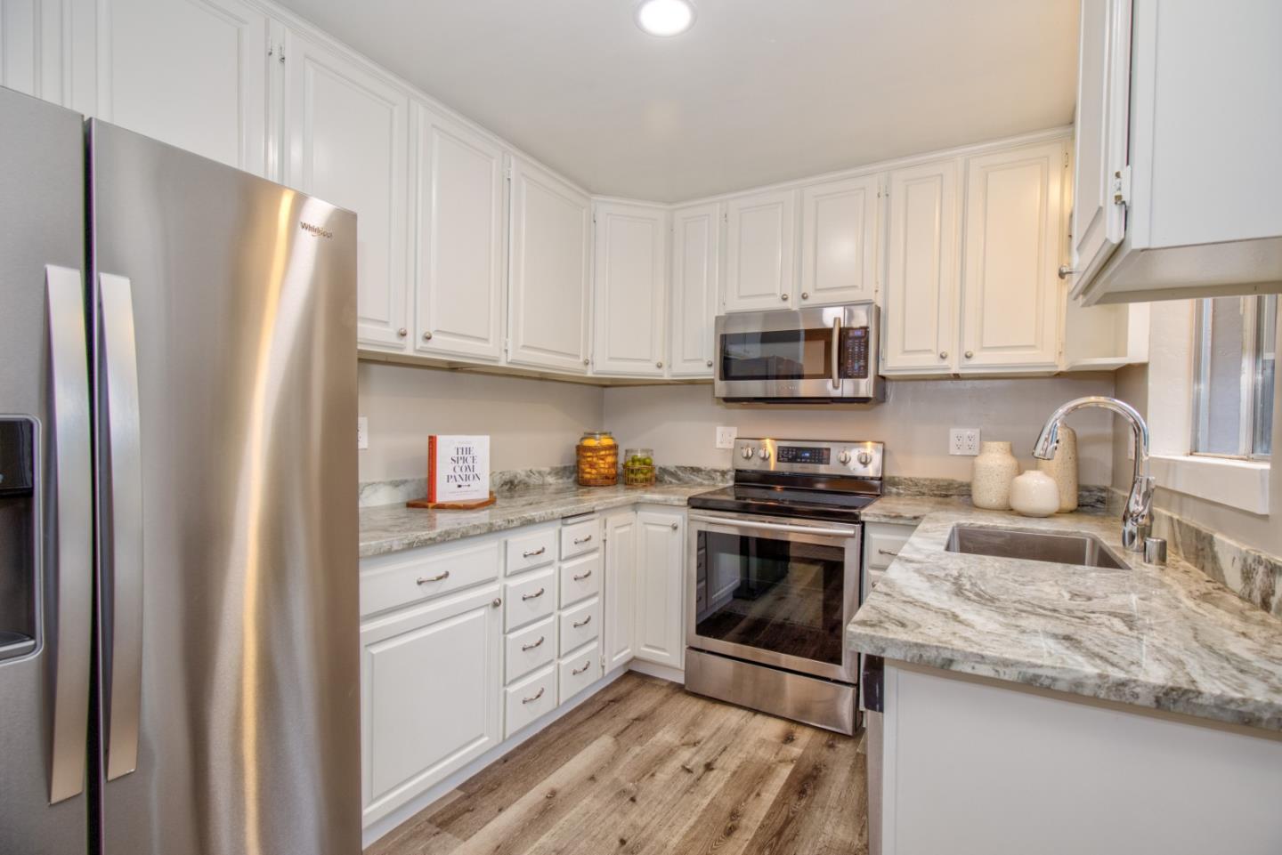 865 Sunset Drive San Carlos, CA 94070 - Photo 7 of 26 a kitchen with granite countertop a stove top oven a sink dishwasher and a refrigerator with cabinets