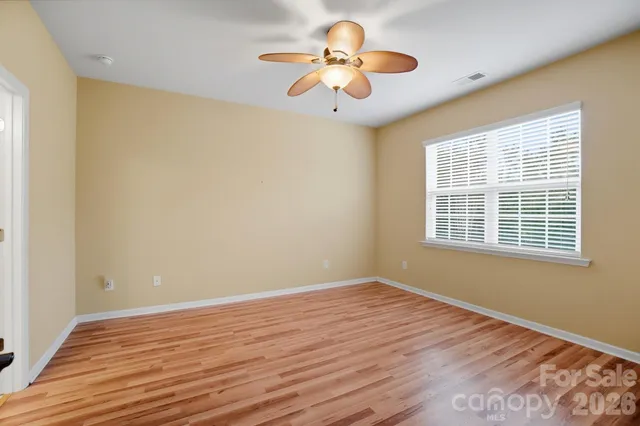 a view of a room with wooden floor and a ceiling fan