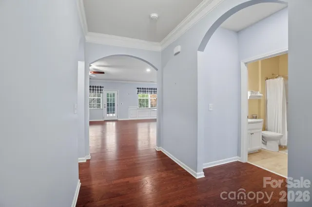 a view of a hallway with wooden floor and a living room
