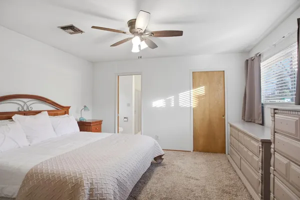 a bedroom with a bed and a ceiling fan