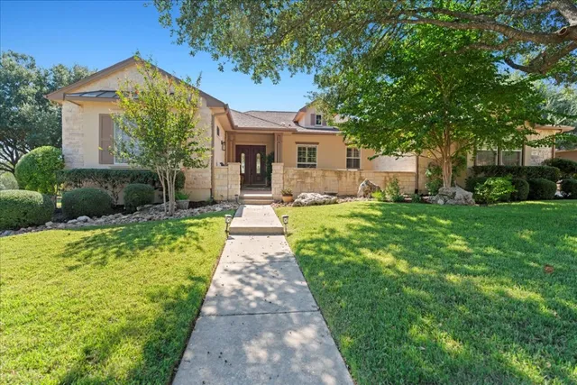 a front view of a house with a yard and trees