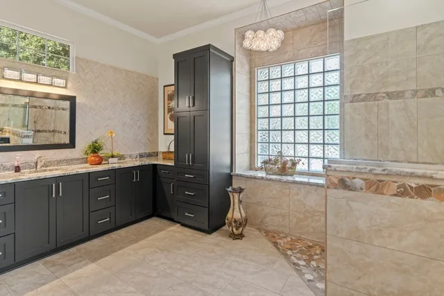 a spacious bathroom with a granite countertop tub sink shower and mirror
