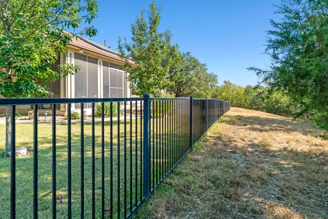 a view of a house with a small yard and wooden fence